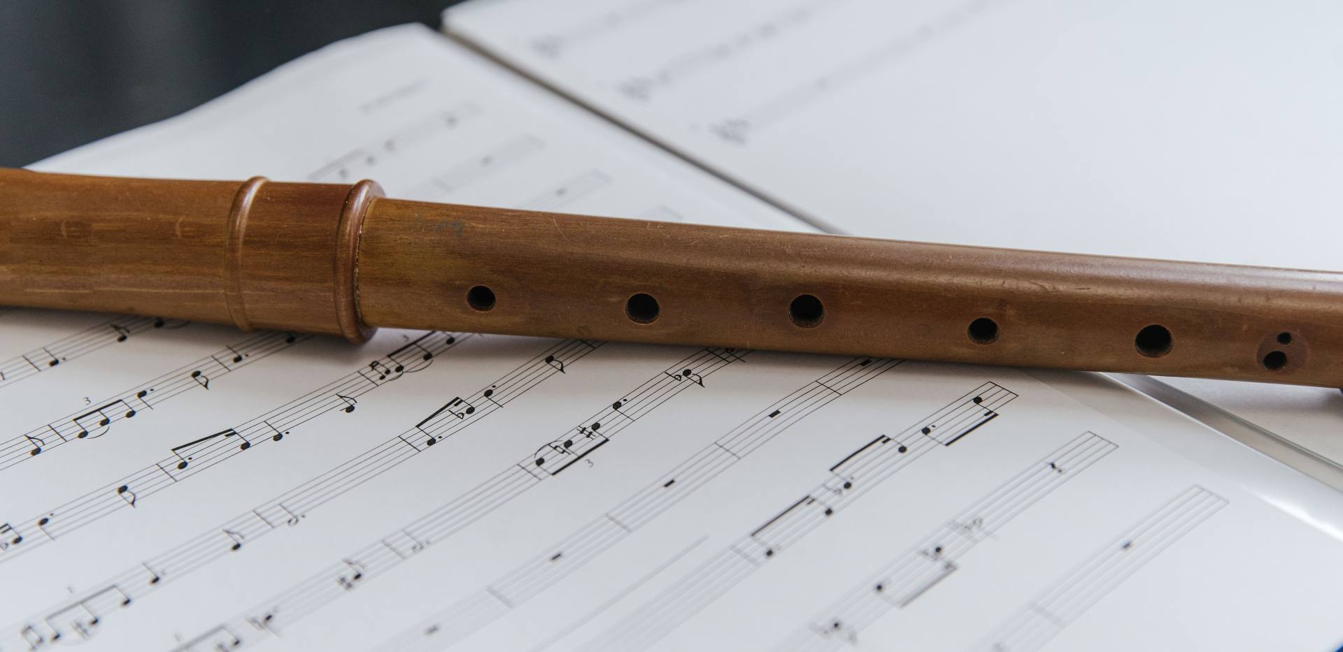Holzflöte liegt auf offenen Notenblättern und betont eine klassische Musikatmosphäre. Foto: SHVETS production/Pexels Holzflöte liegt auf offenen Notenblättern und betont eine klassische Musikatmosphäre. Foto: SHVETS production/Pexels