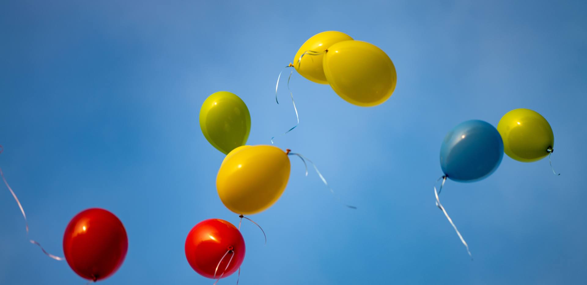 bunte-luftballons-schweben-gegen-blauen-himmel bunte-luftballons-schweben-gegen-blauen-himmel